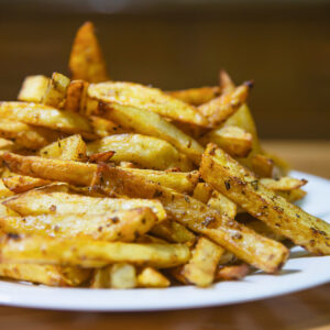 delicious-french-fried-potato-mix-with-chilly-powder-wooden-table